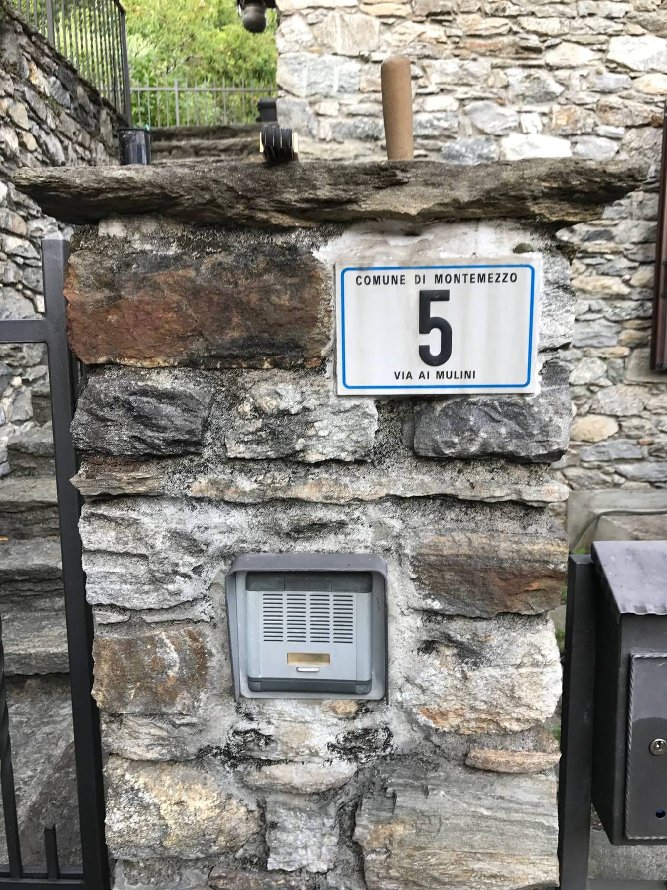 Husnummerskilt fra Comune di Montemezzo på steinmuren ved Villa Oppilia