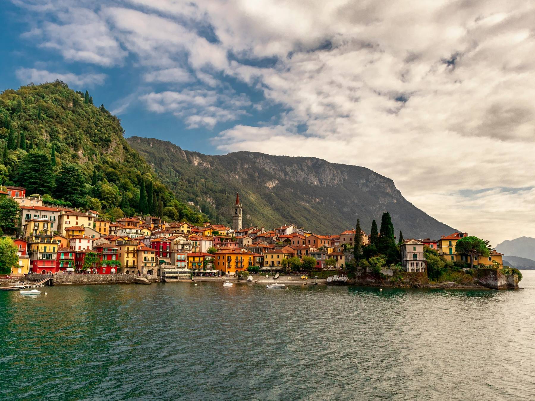 Varenna på østsiden av Comosjøen med fargerike hus langs vannet og fjell bak